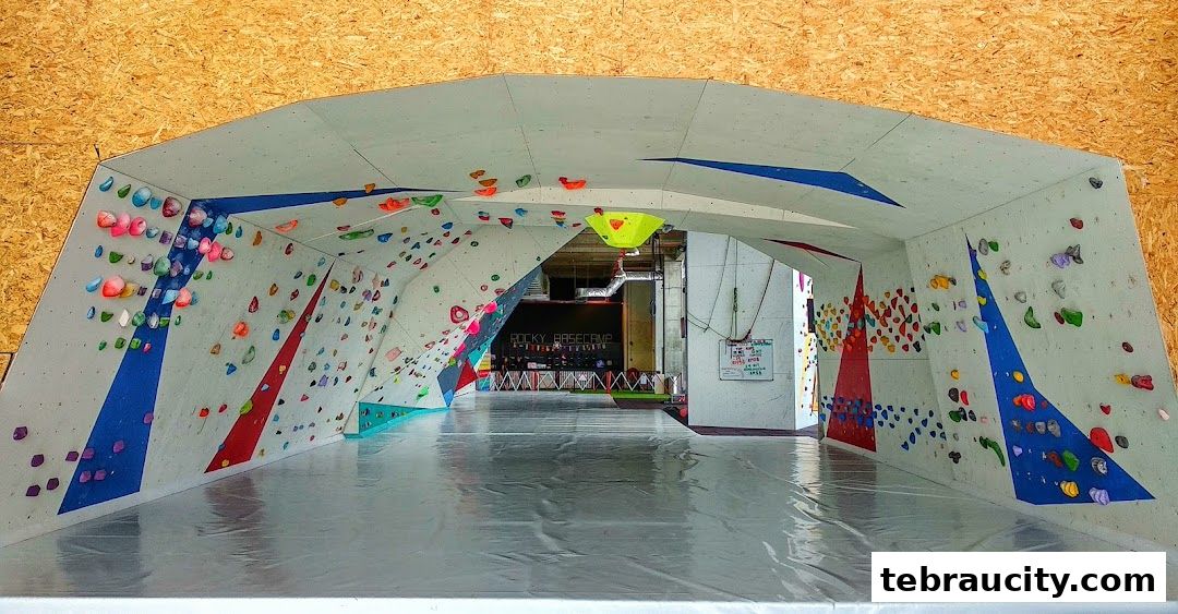 Interior view of a climbing gym with colorful holds on angled walls.