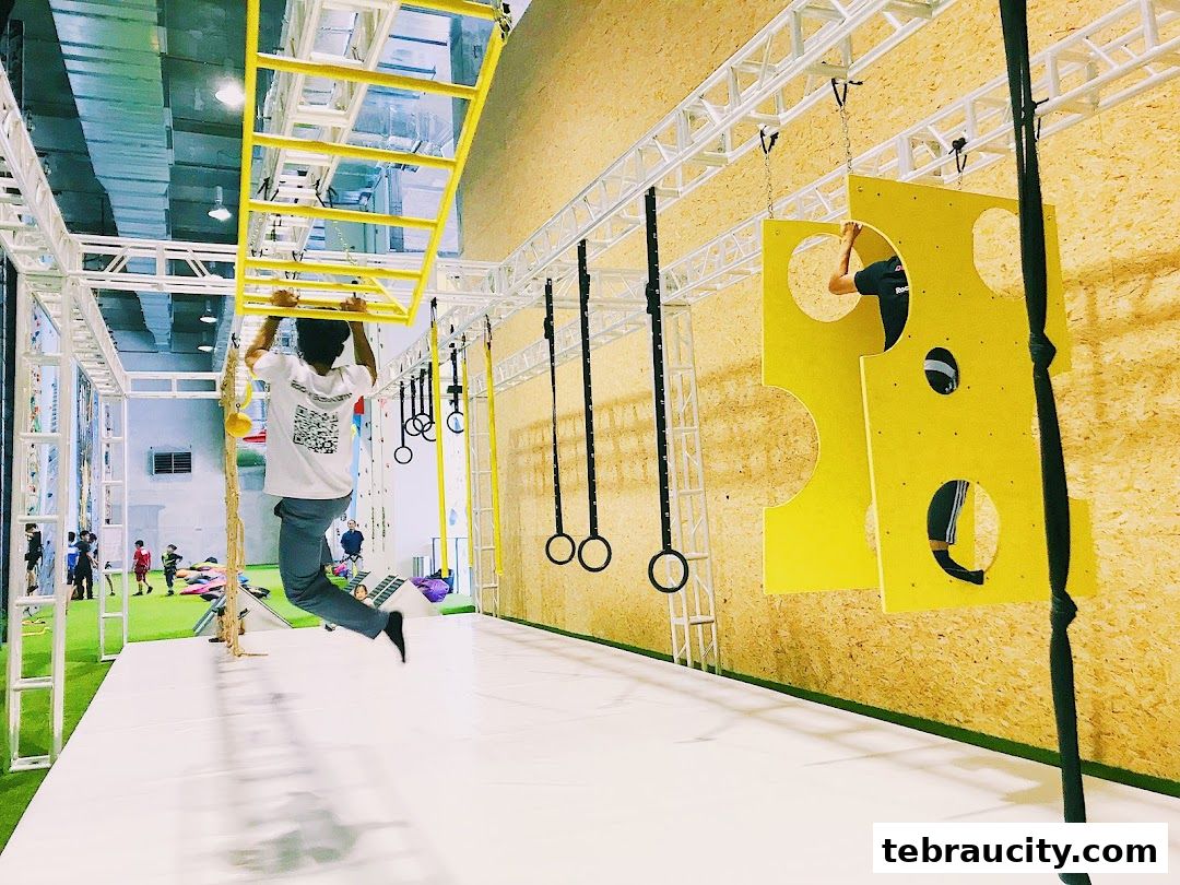 People training on an indoor obstacle course with monkey bars and climbing challenges.