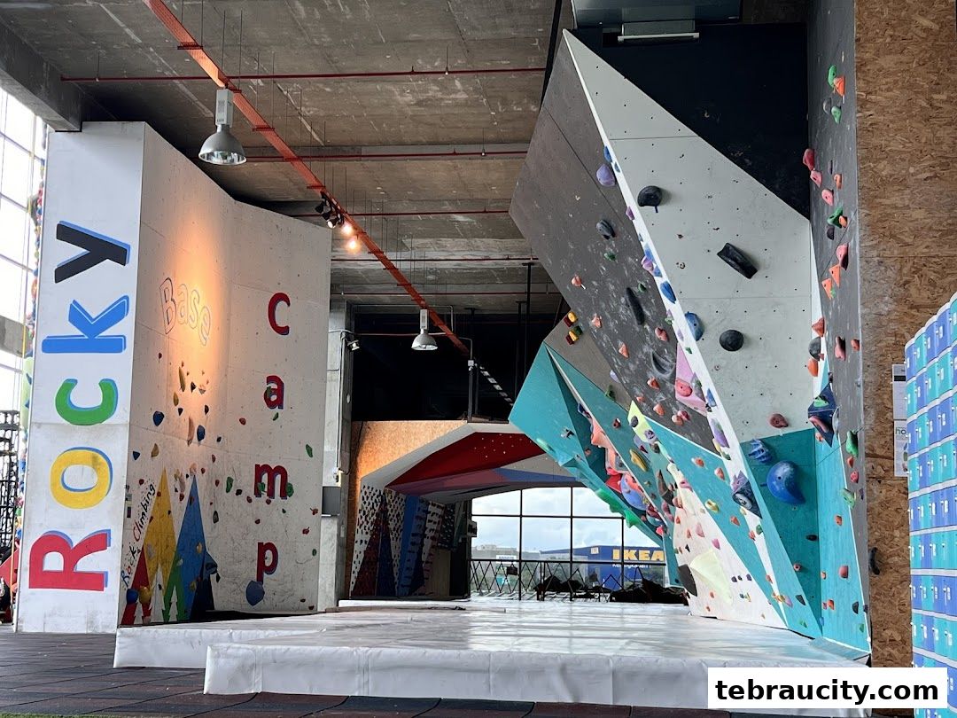 Interior view of a modern indoor rock climbing gym with colorful climbing walls and holds.