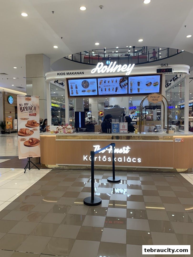 The Rollney shop front in a mall, featuring a menu board and a 'Pick Up Here' sign.