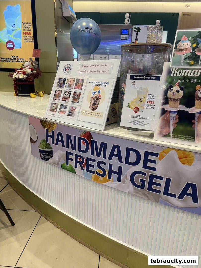 A Romanlin ice cream and tea shop counter displaying cute cartoon ice cream and a promotion for free lemonade.