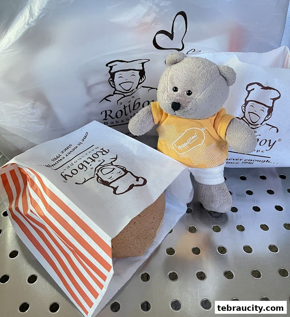 A teddy bear poses with Rotiboy baked goods in branded packaging.