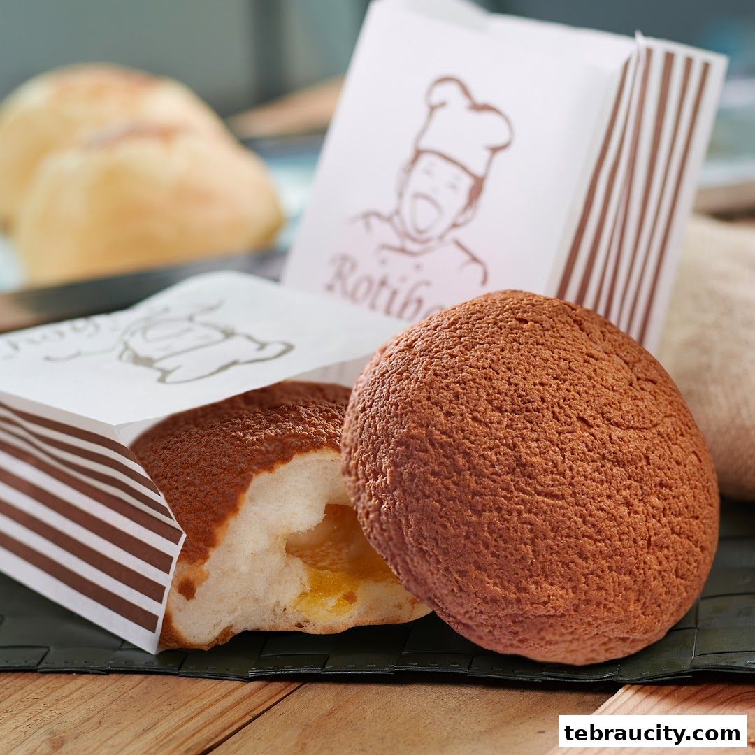Close-up of Rotiboy buns, one whole and one cut open, with branded packaging.