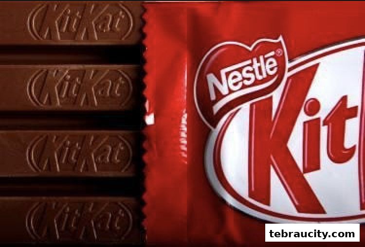 A close-up shot of several Kit Kat chocolate bars next to its iconic red packaging.