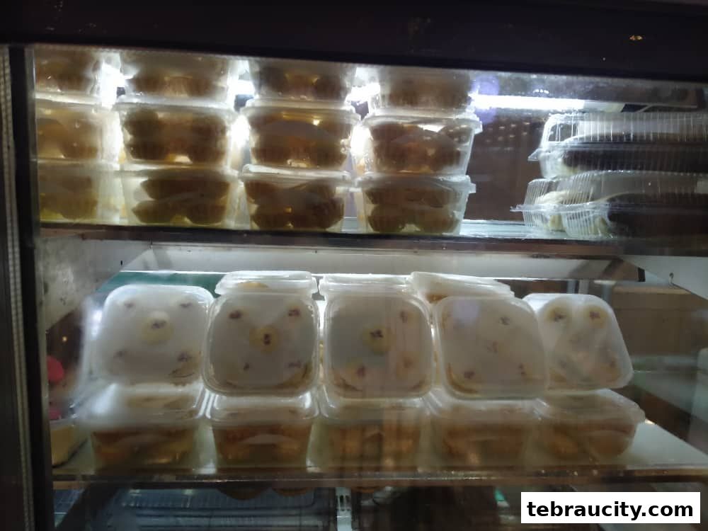 A display case filled with various desserts in clear plastic containers.