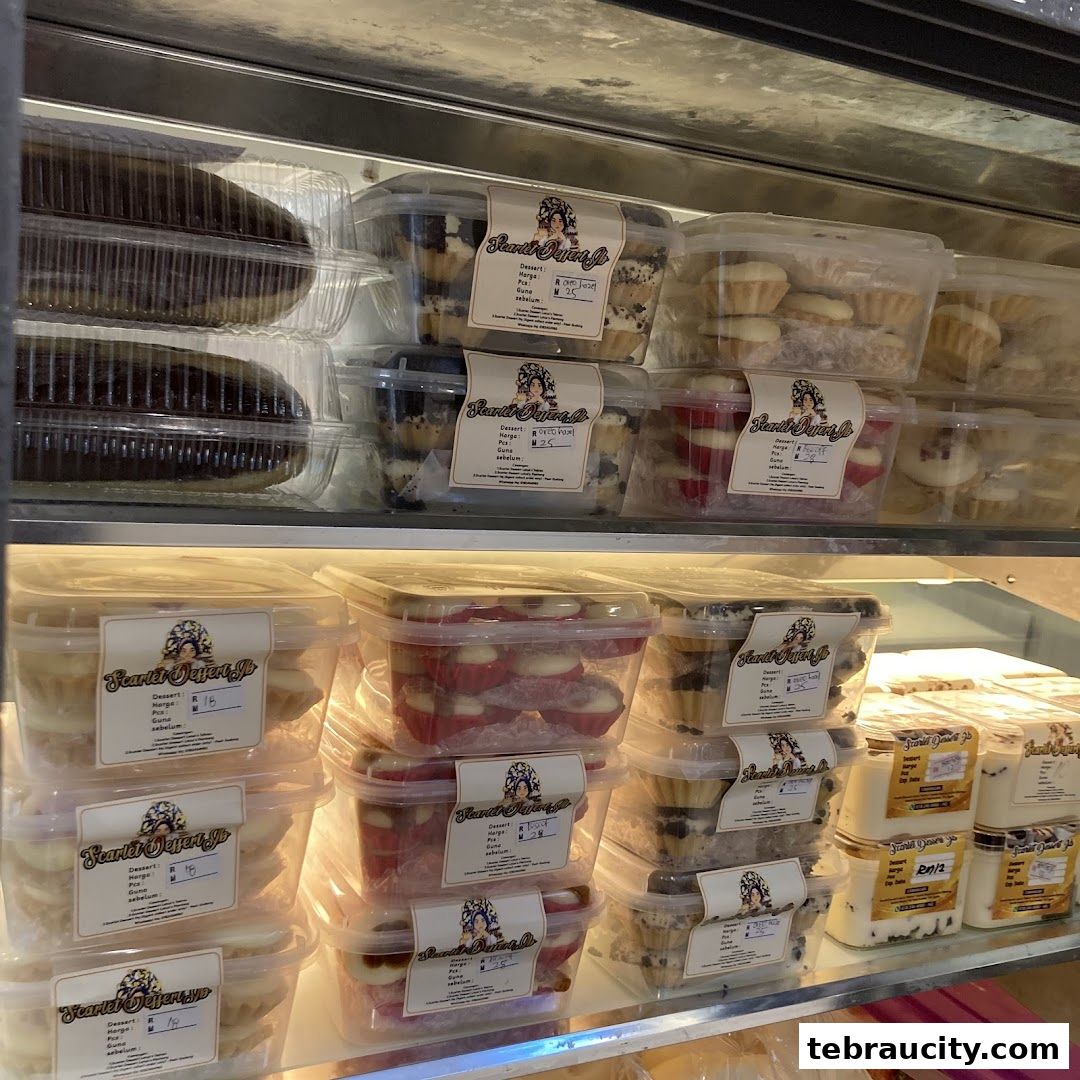 A display case filled with various pre-packaged desserts from Scarlet Dessert Jb.
