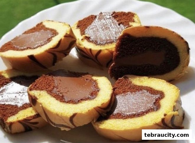 Close-up of sliced chocolate swiss rolls with a creamy chocolate filling on a white plate.