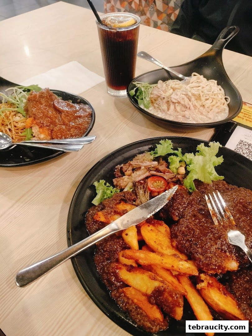 A table setting with three meals and a drink, featuring steak, fries, pasta, and noodles.