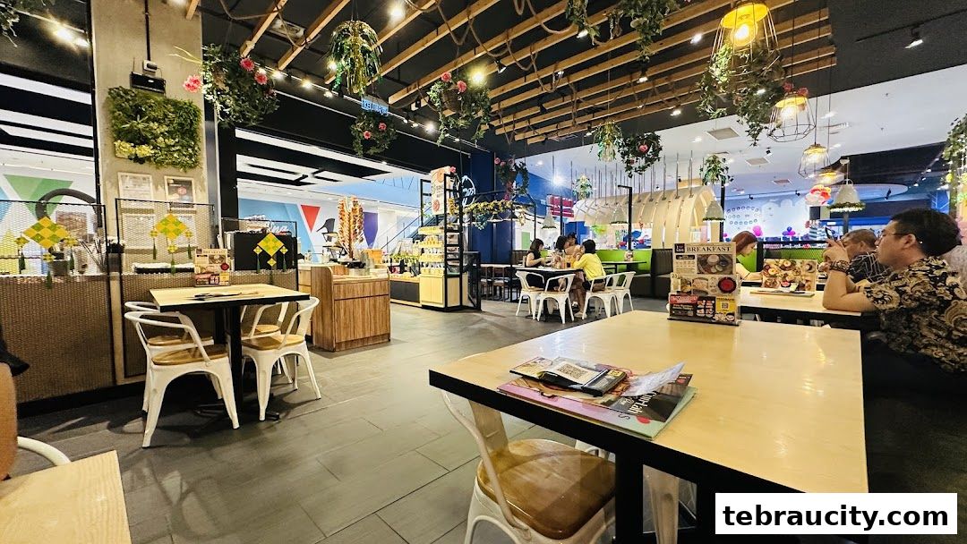 Interior view of a brightly lit cafe with tables, chairs, and hanging plants.