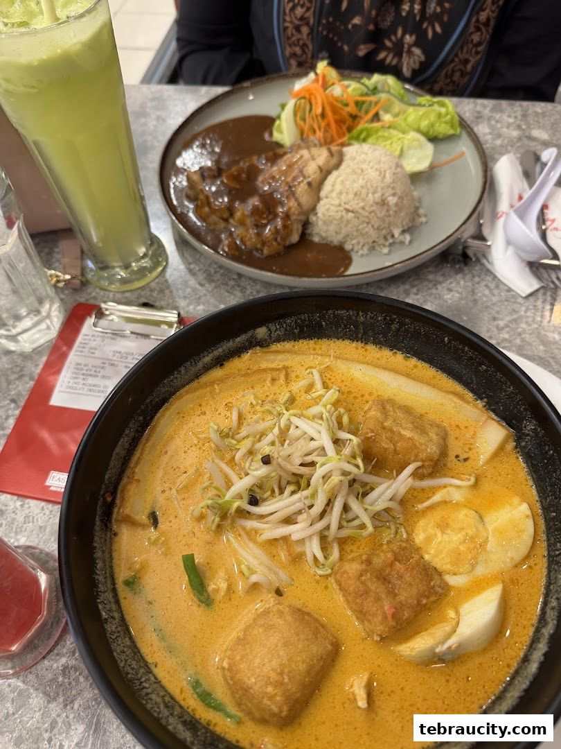 A close-up of two delicious meals and a green drink on a table at Secret Recipe.