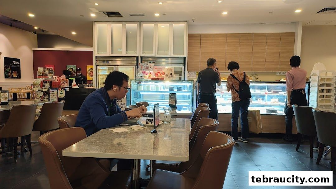 People dining and browsing cakes at a Secret Recipe cafe.