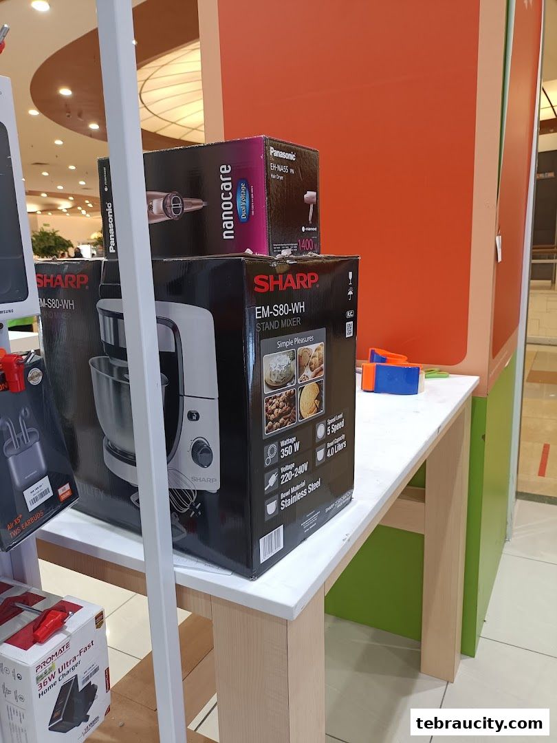 Display of kitchen appliances including a Sharp stand mixer and Panasonic hair dryer.