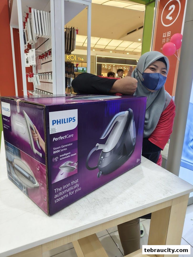 A smiling person in a mask gives a thumbs up next to a large box for a Philips PerfectCare steam generator iron.
