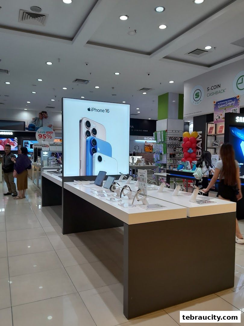 A display of the iPhone 16 with various accessories and other electronic products in a retail store.
