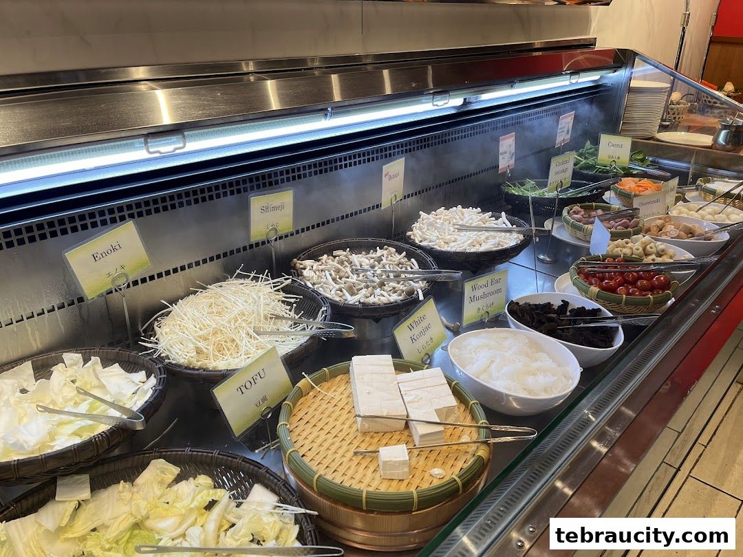 A display of fresh ingredients for hot pot, including various mushrooms, tofu, and vegetables.