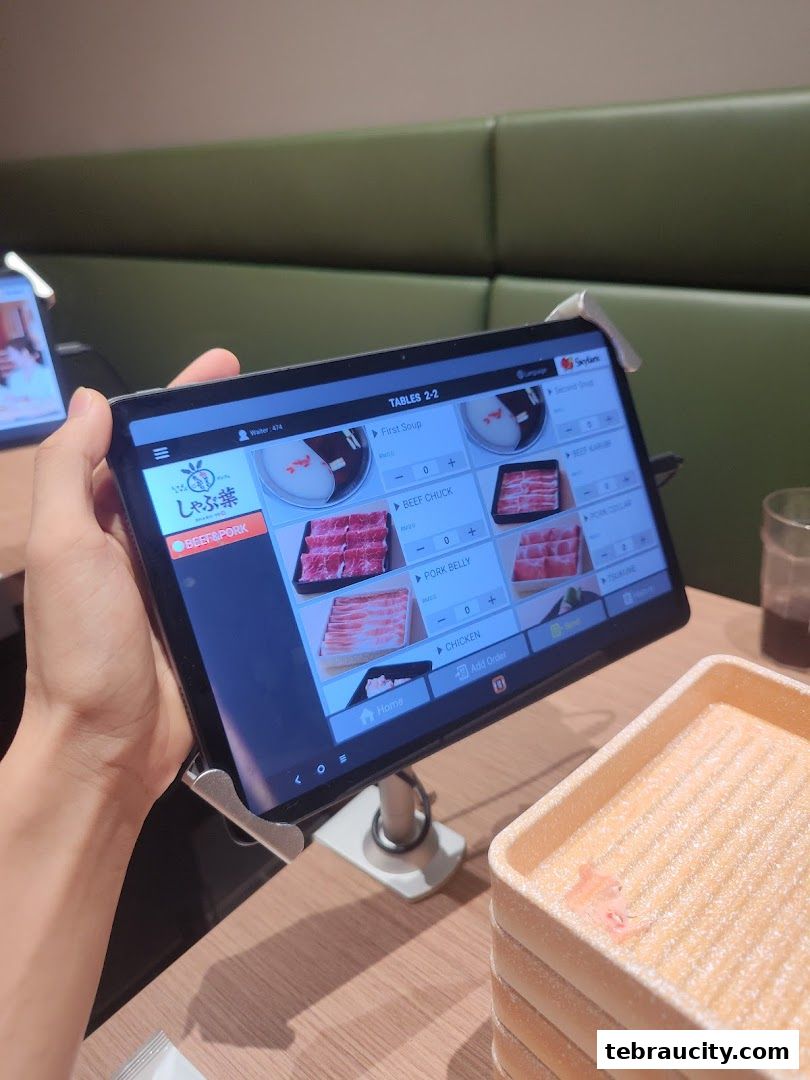 A tablet displays a digital menu for Shabu-Yo, showing various meat options for shabu-shabu.
