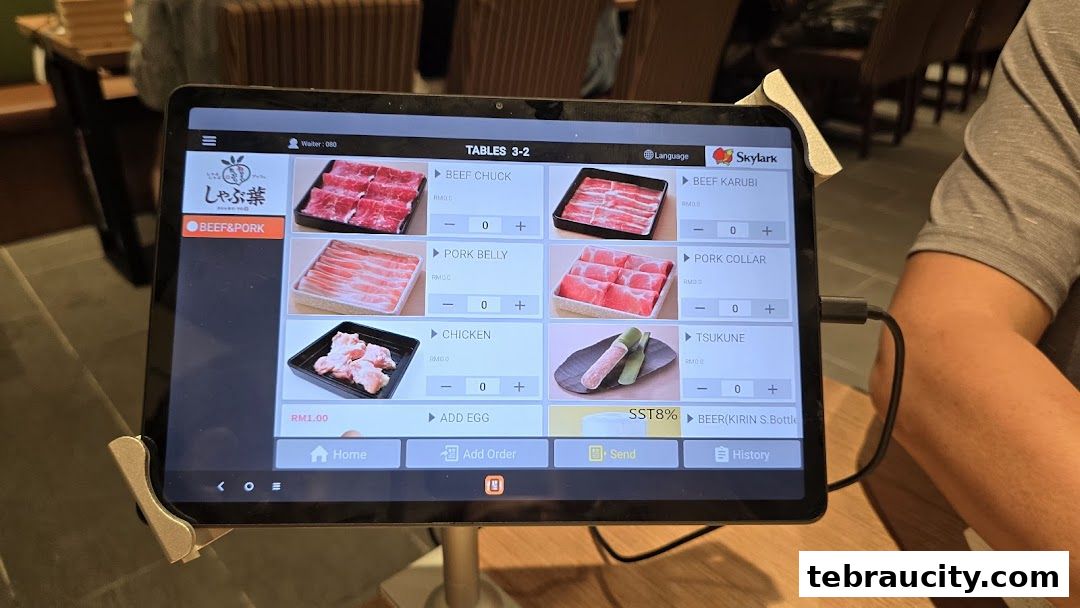 A tablet displays a digital menu for Shabu-Yo, showing various meat and food options for ordering.
