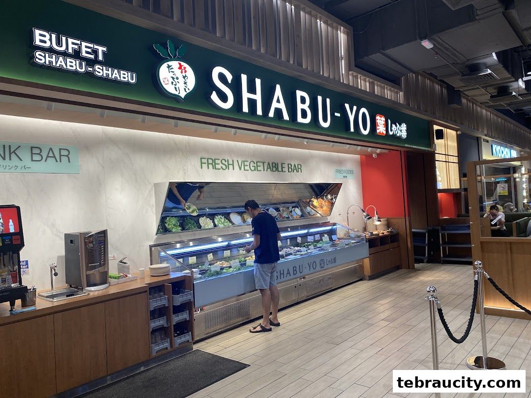 Shabu-Yo restaurant entrance with a fresh vegetable bar and a customer selecting food.