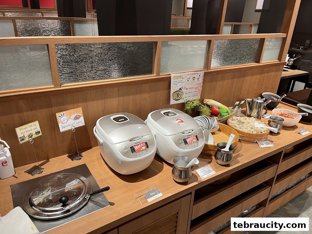Buffet spread with rice cookers, curry, and various side dishes.