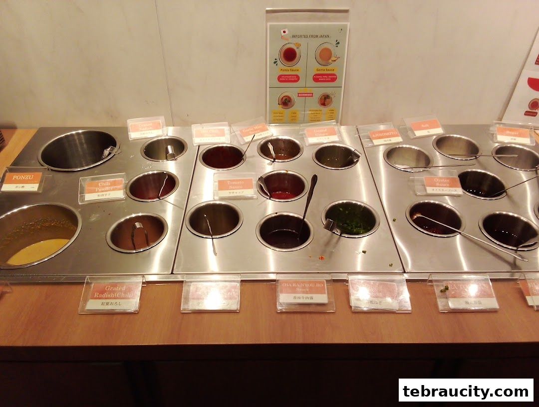A variety of sauces and condiments are displayed in metal containers for customers to choose from.
