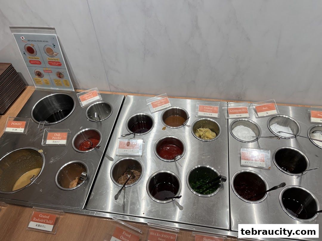 A variety of sauces and condiments are displayed in stainless steel containers for a hot pot restaurant.