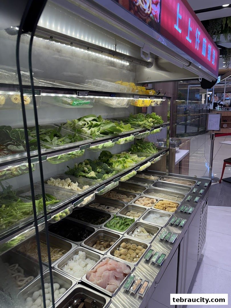 A display of fresh ingredients for Mala Tang, including vegetables, mushrooms, and fish.