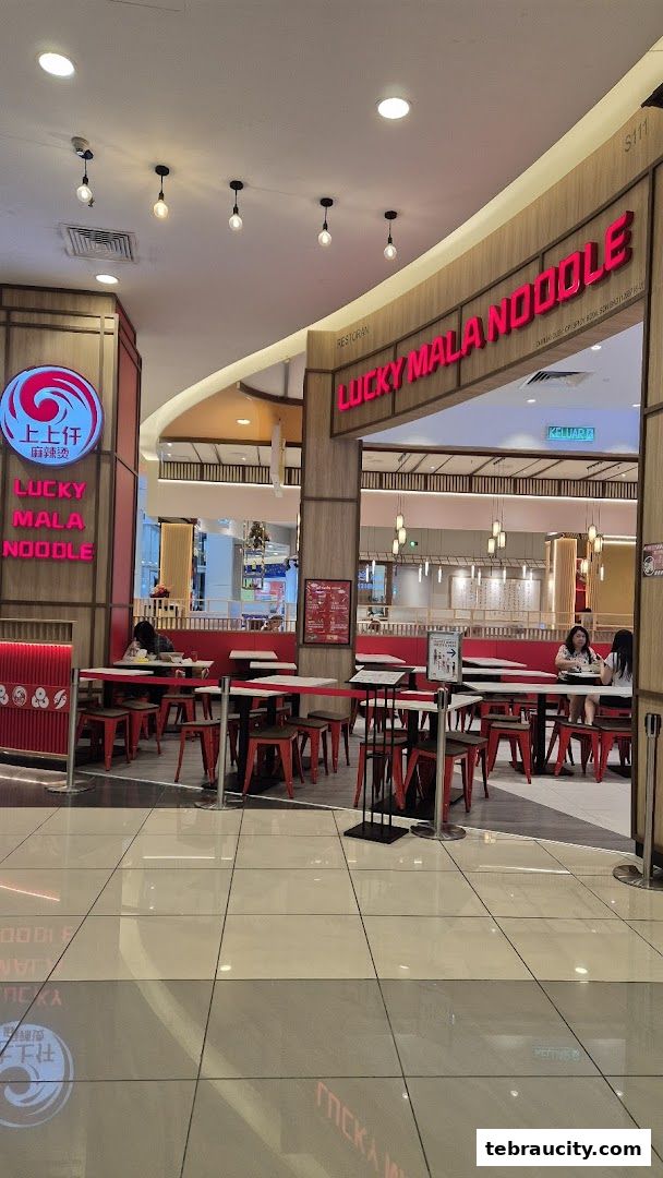 The entrance of Lucky Mala Noodle restaurant with red seating and signage.