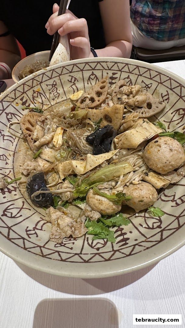 A close-up of a delicious bowl of Mala Tang with various ingredients and chopsticks.