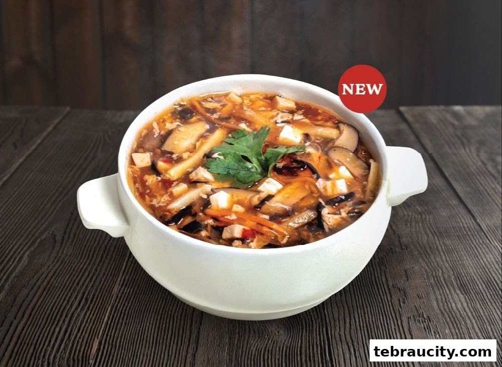 A bowl of hot and sour soup with tofu, mushrooms, and vegetables, garnished with parsley.