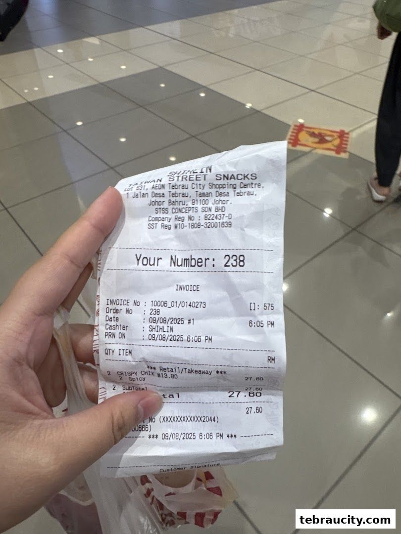 A receipt from Shihlin Taiwan Street Snacks is held up, showing purchased items and total cost.