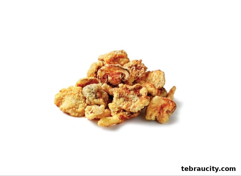A pile of crispy, golden-brown fried mushrooms seasoned with spices.