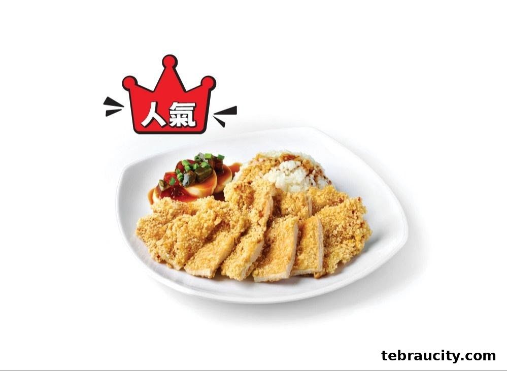 A plate of crispy fried chicken with rice and braised eggs, topped with sauce and green onions.