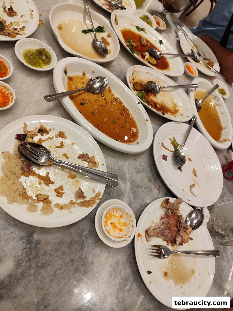 A table full of dirty plates and leftover food after a meal.