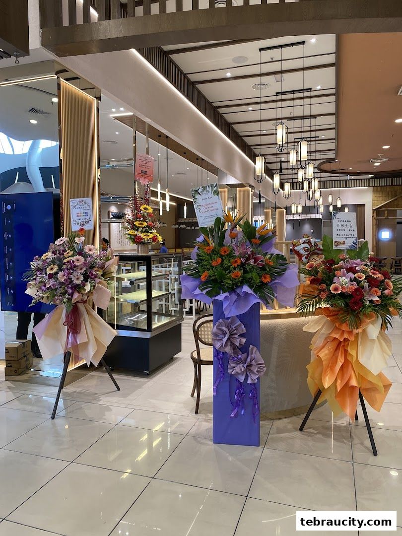 A shop entrance decorated with congratulatory flower stands and a lion dance prop.
