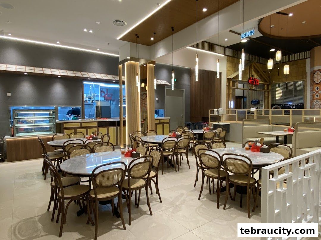 Interior view of a restaurant with tables, chairs, and a visible kitchen area.