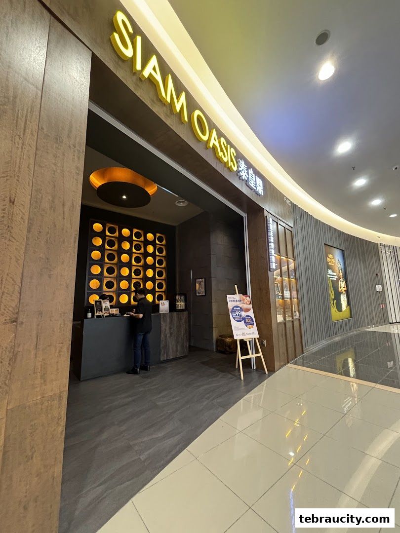 The entrance of Siam Oasis restaurant with a promotional sign outside.