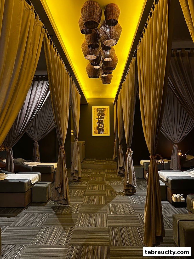 Interior view of a spa with massage beds, curtains, and unique pendant lighting.