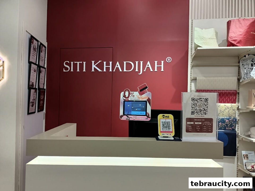 The interior of a Siti Khadijah store with a counter, branding, and promotional displays.