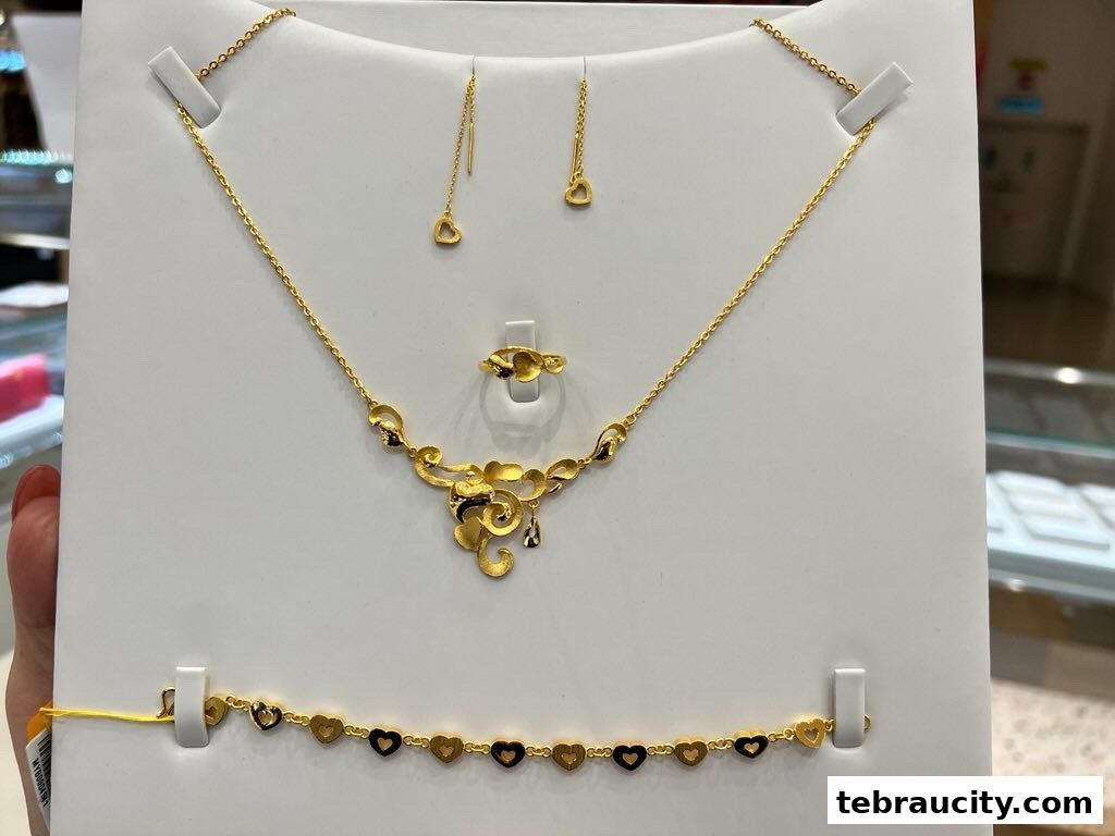 A display of elegant gold jewelry, including a necklace, earrings, ring, and bracelet with heart motifs.