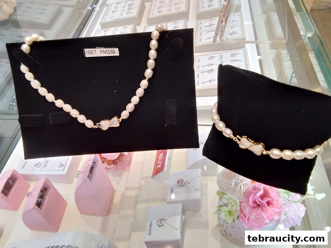 Elegant pearl necklaces and bracelets displayed in a jewelry store with price tags.