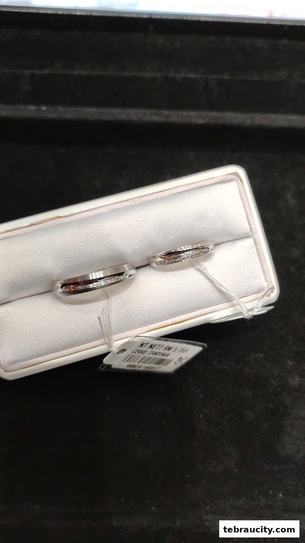 Two elegant diamond wedding bands displayed in a white jewelry box.