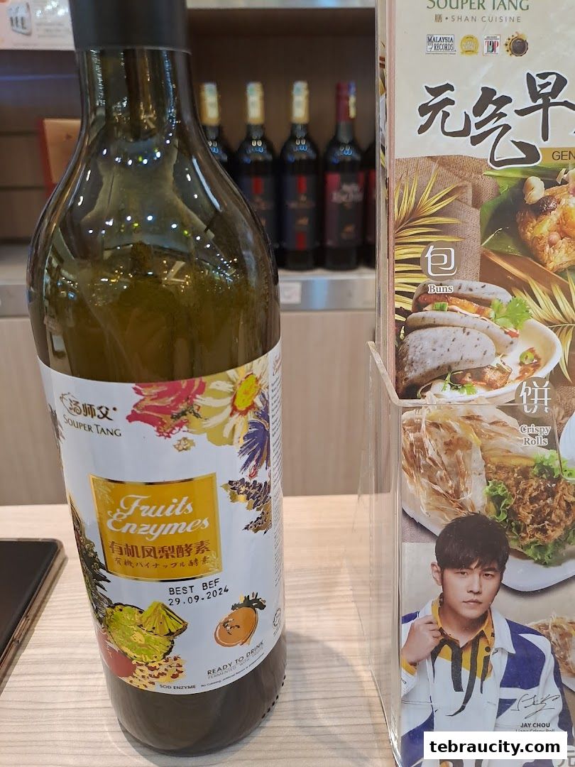 A bottle of 'Fruits Enzymes' and a menu featuring 'Buns' and 'Crispy Rolls' with Jay Chou.