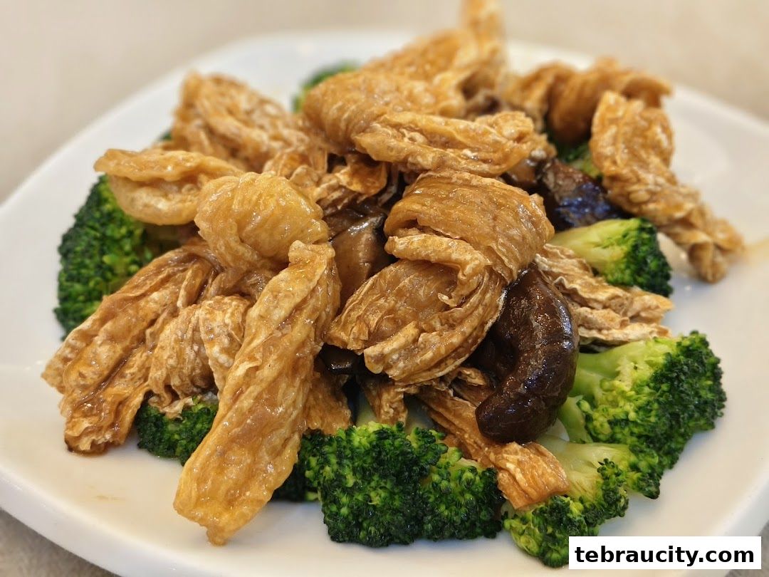 A close-up shot of a delicious dish featuring fried tofu skin, broccoli, and shiitake mushrooms.