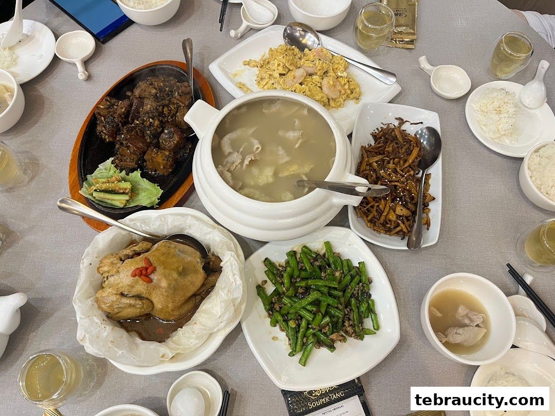 A table laden with various delicious Chinese dishes, including soup, chicken, and stir-fried vegetables.