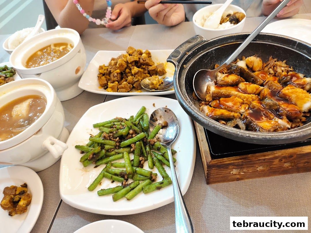 A table laden with various delicious Chinese dishes, including stir-fried green beans and braised fish.