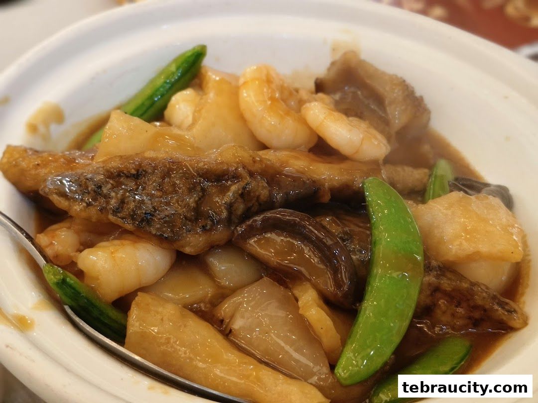 A close-up shot of a delicious seafood and vegetable dish in a white bowl.
