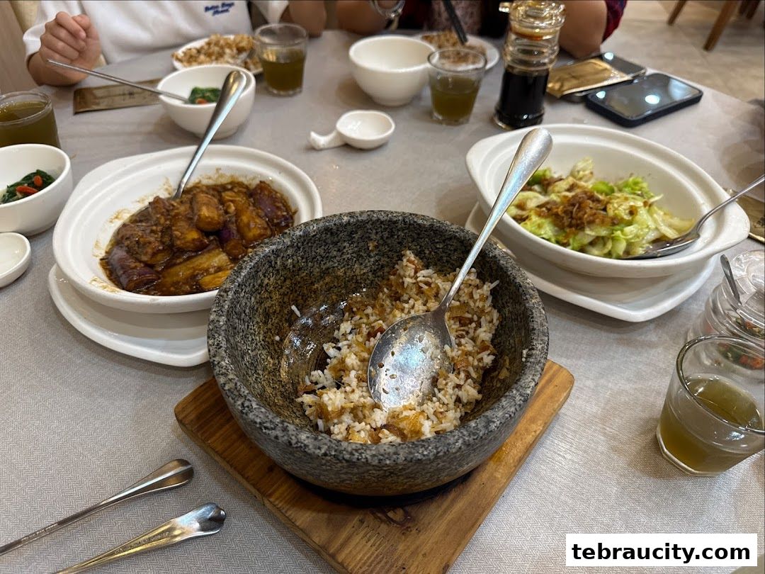 A table setting with various dishes, including stir-fried eggplant, vegetables, and rice.