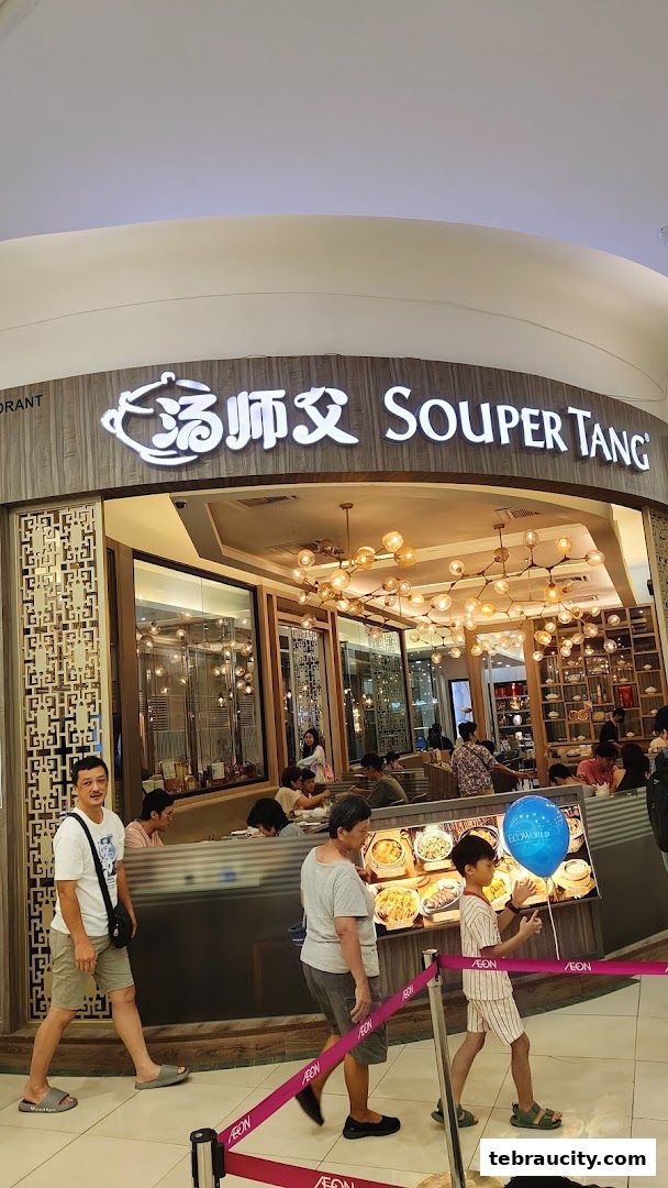 The exterior of the Souper Tang restaurant with customers inside and outside.