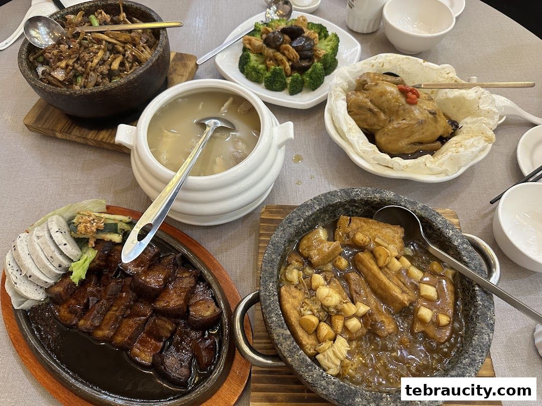 A table laden with various delicious Chinese dishes, including soup, roasted meats, and stir-fried items.