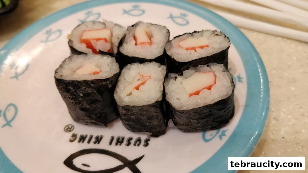 A plate of sushi rolls with crab sticks on a plate with the Sushi King logo.